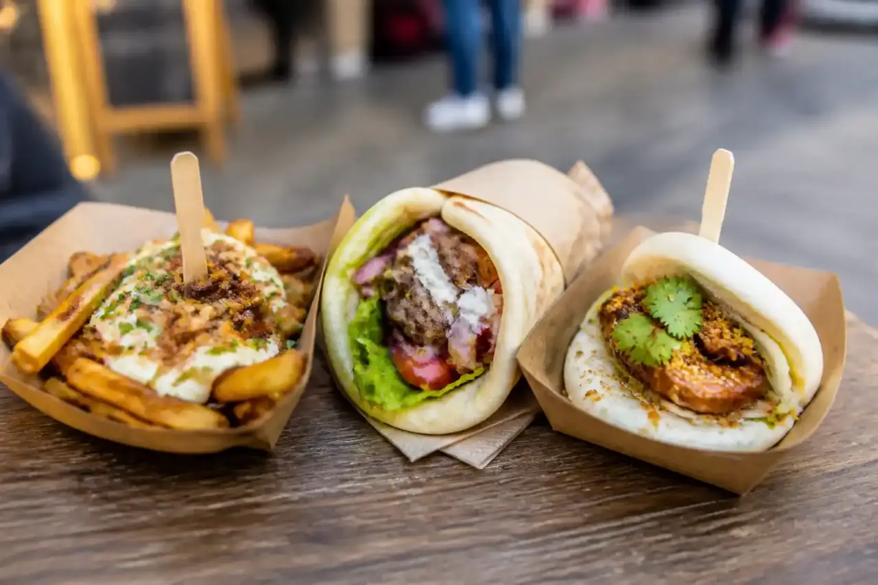 Table de street food variée avec tacos, bao buns et burgers gourmets
